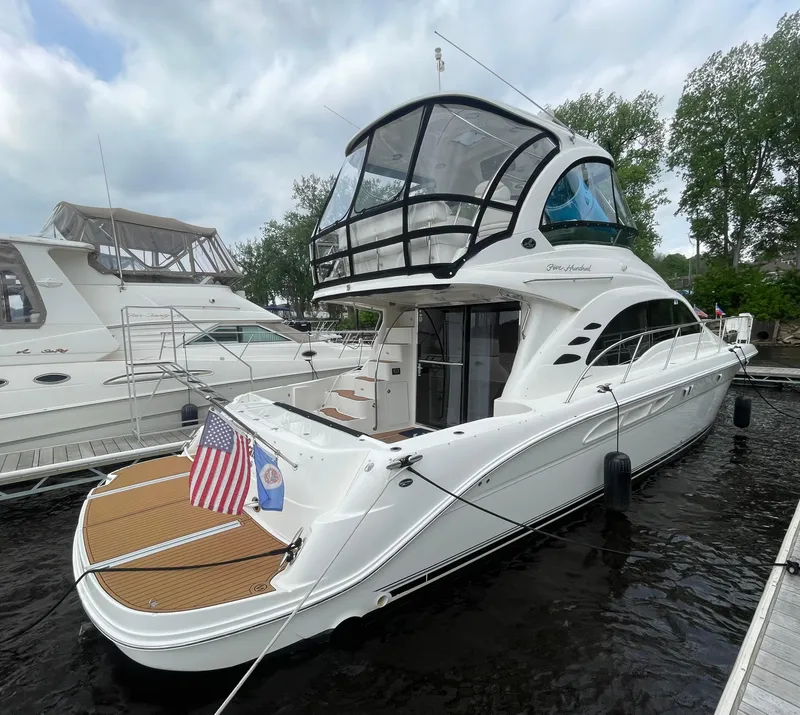 Slide: The Image of 2005 Sea Ray 500 Sedan Bridge yacht docked, featuring sleek design and spacious upper deck. - 13