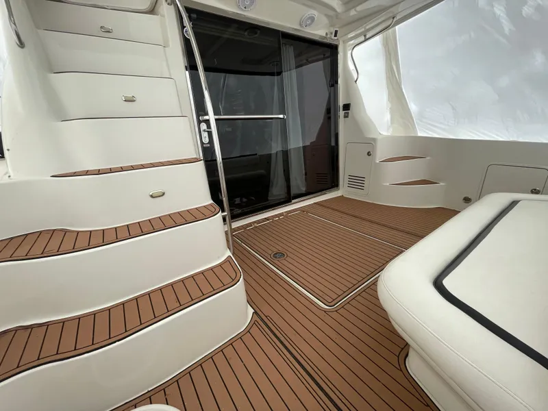 Slide: The Image of 2005 Sea Ray 500 Sedan Bridge interior with teak flooring and white seating. - 17