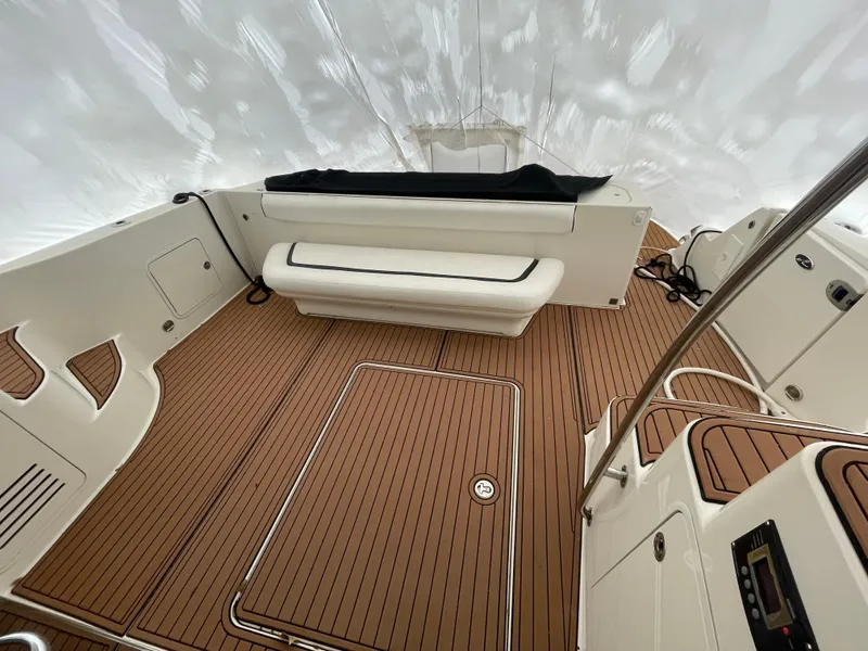 Slide: The Image of 2005 Sea Ray 500 Sedan Bridge interior with teak flooring and white seating. - 18