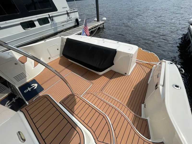 Slide: The Image of 2005 Sea Ray 500 Sedan Bridge yacht with teak deck, docked by the water. - 20