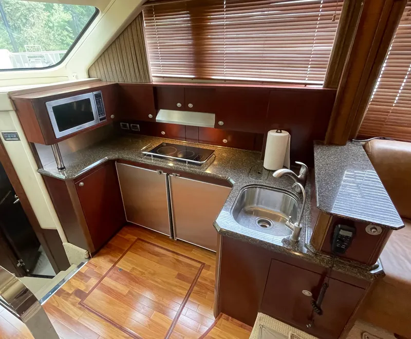 Slide: The Image of Luxurious 2005 Sea Ray 500 Sedan Bridge yacht kitchen with modern appliances and wood flooring. - 49