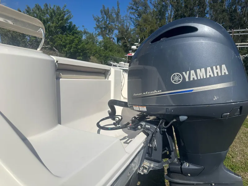 Slide: The Image of 2018 Cobia 220 Center Console with Yamaha four-stroke engine, outdoor setting. - 12