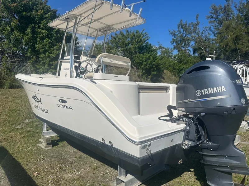 Slide: The Image of 2018 Cobia 220 Center Console boat with Yamaha engine, parked on grass. - 2