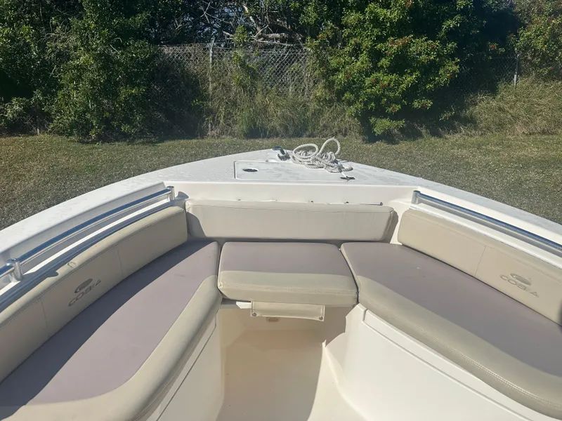 Slide: The Image of 2018 Cobia 220 Center Console boat with cushioned seating and rope on deck. - 20