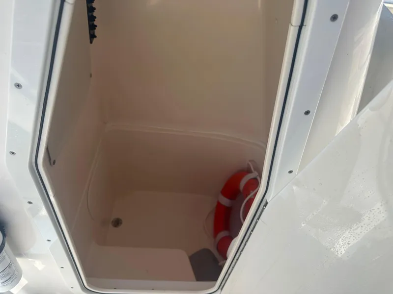 Slide: The Image of Storage compartment with life preserver on a 2018 Cobia 220 Center Console boat. - 25