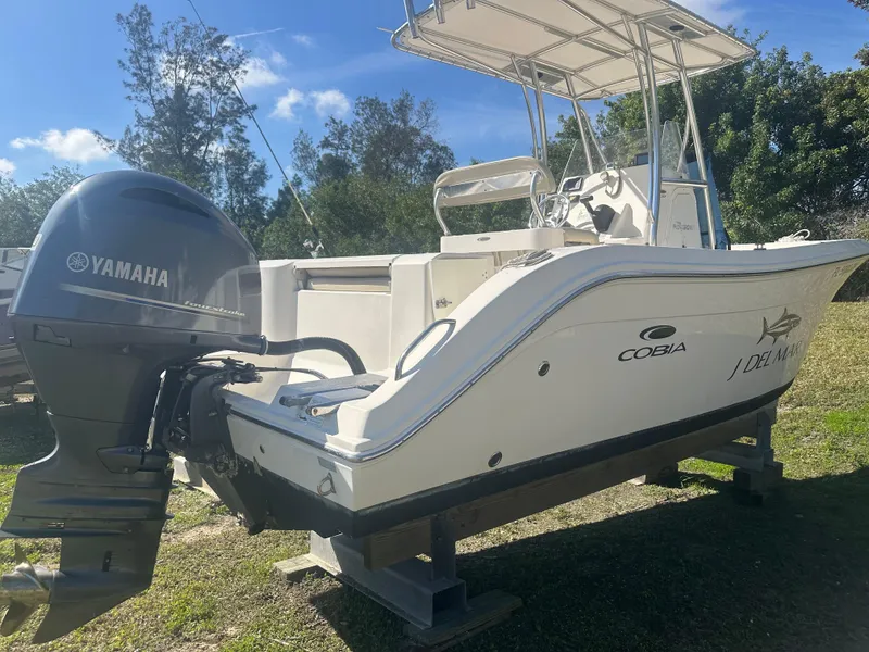 Slide: The Image of 2018 Cobia 220 Center Console boat with Yamaha outboard engine, parked on grass. - 4