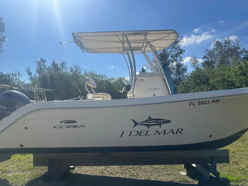 Slide: The Image of 2018 Cobia 220 Center Console boat on display outdoors. - 5