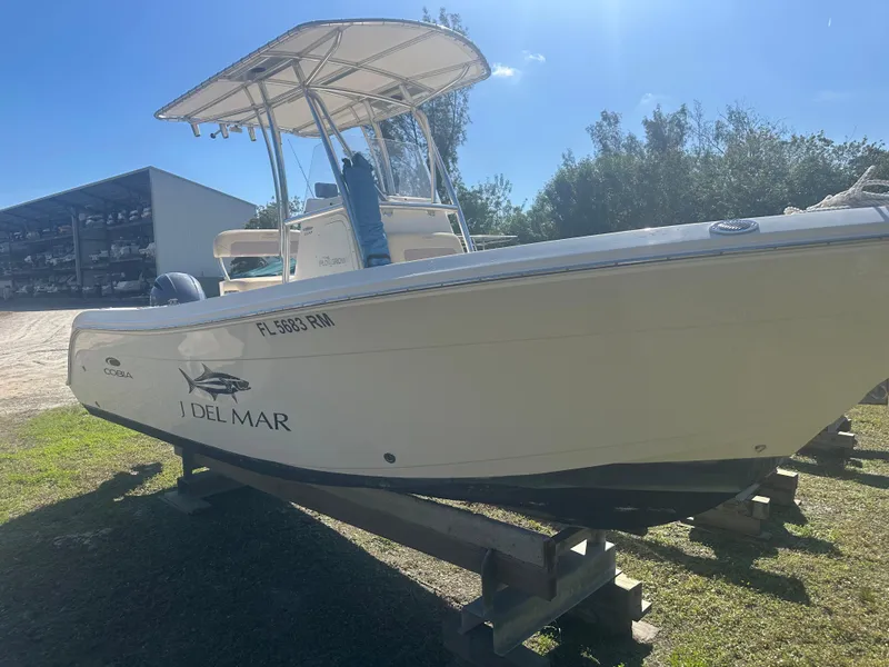Slide: The Image of 2018 Cobia 220 Center Console boat on display outdoors. - 6