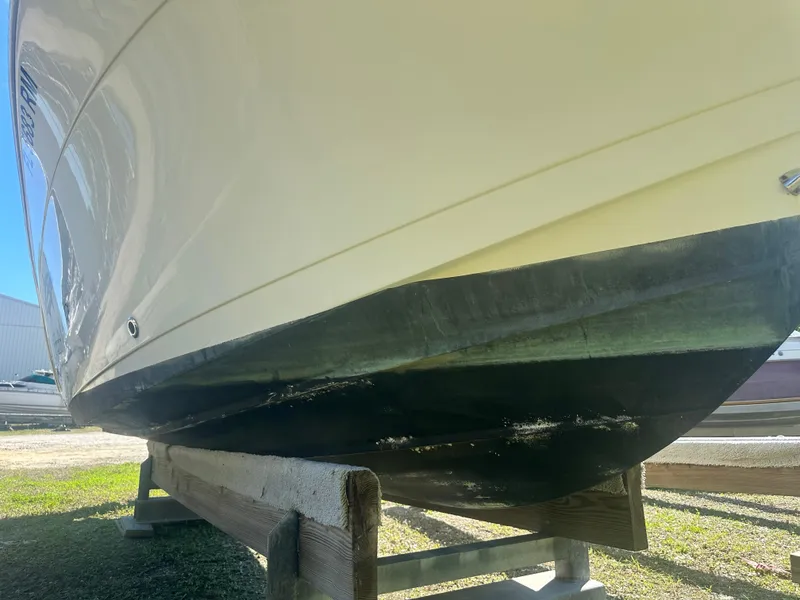 Slide: The Image of 2018 Cobia 220 Center Console boat on wooden stand, viewed from below. - 8
