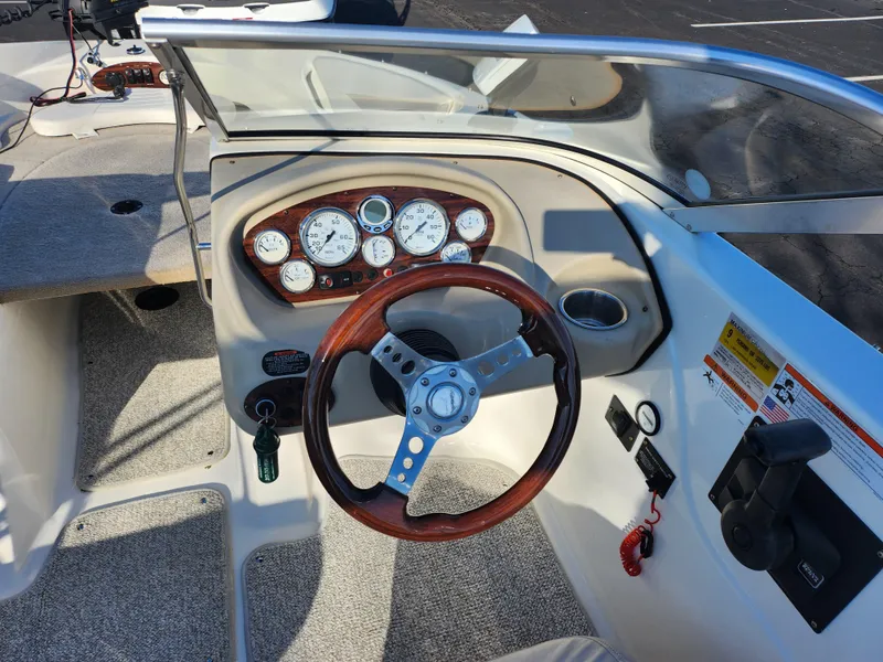 Slide: The Image of 2008 Glastron GT 205 Ski & Fish boat dashboard with wood-accented steering wheel. - 13