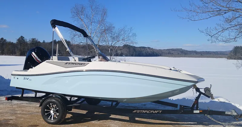Slide: The Image of 2025 Starcraft SV 16 OB boat on trailer by a frozen lake. - 1