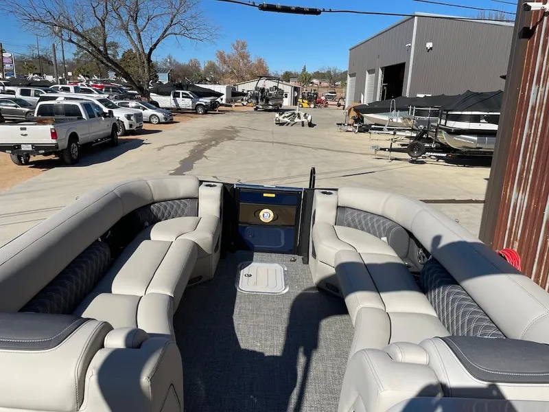 Slide: The Image of 2025 Barletta Lusso 25QSS pontoon boat with spacious seating, parked outdoors. - 6