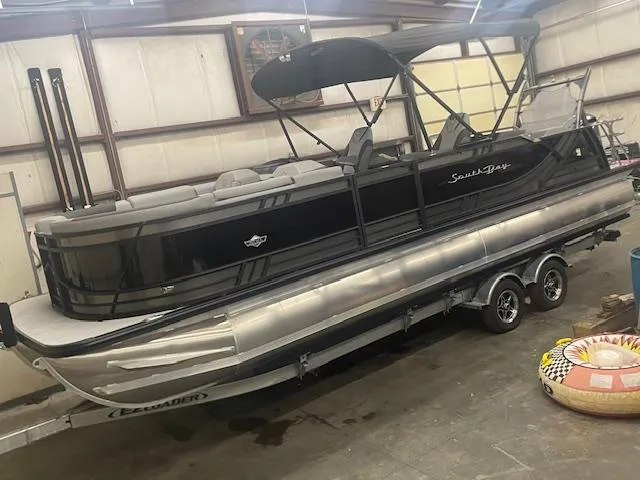The Image of 2025 South Bay 500 pontoon boat in a garage, featuring a sleek black design. - 0