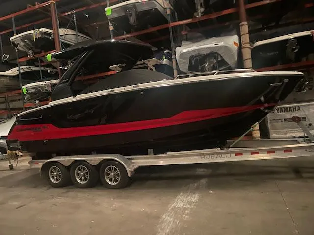 Slide: The Image of 2025 Chaparral 28 Surf boat on trailer in storage facility. - 2