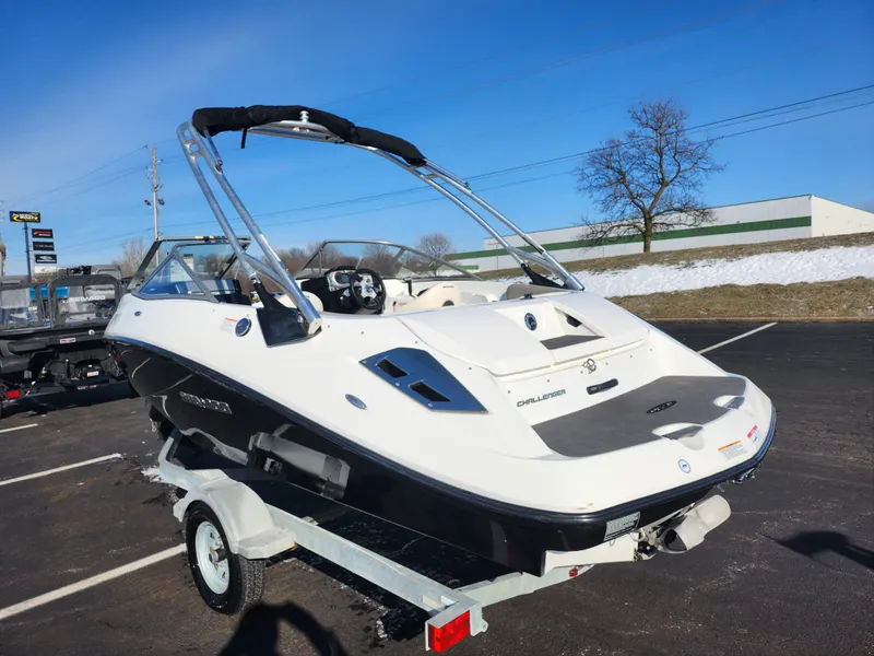 Slide: The Image of 2012 Sea-Doo Sport Boats 180 Challenger SE on trailer, parked outdoors under clear blue sky. - 3