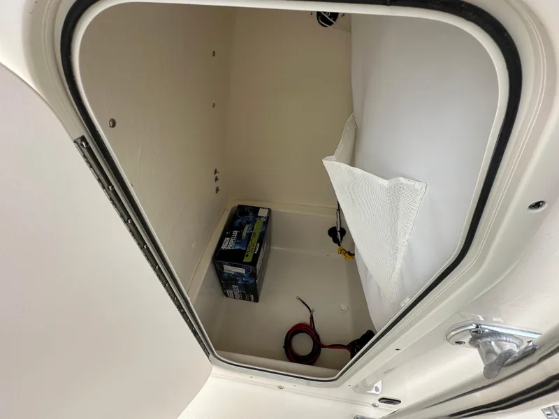 Slide: The Image of Storage compartment of 2025 Bulls Bay 200 Center Console boat, featuring a battery and cables. - 7