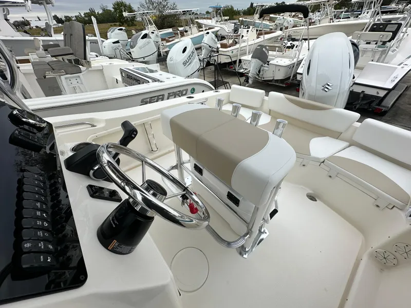 Slide: The Image of 2025 Bulls Bay 200 Center Console boat interior with steering wheel and seating, surrounded by other boats. - 8