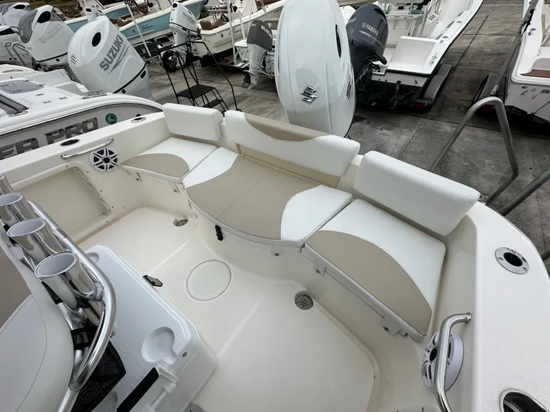 Slide: The Image of 2025 Bulls Bay 200 Center Console boat interior with cushioned seating and fishing rod holders. - 9