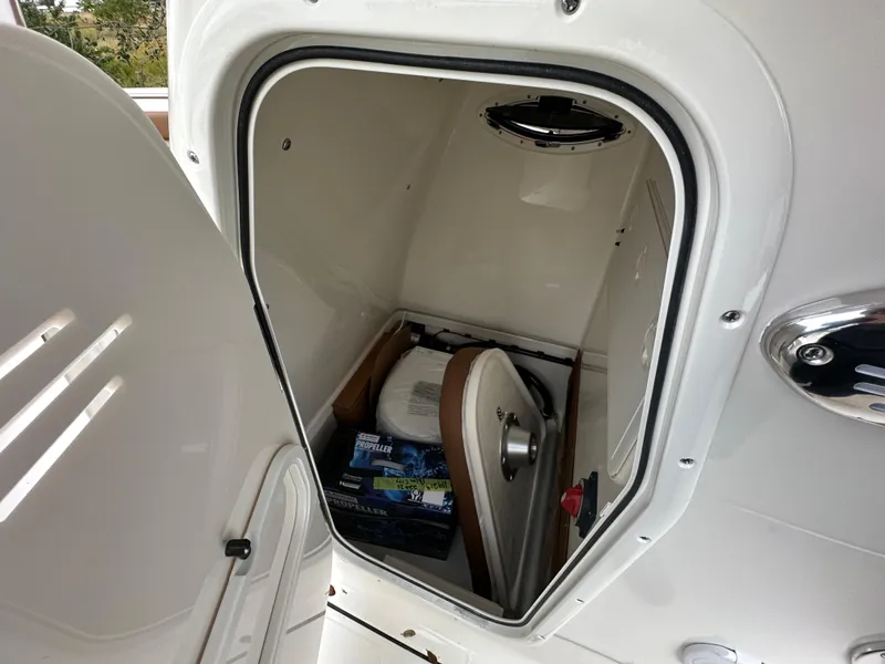 Slide: The Image of 2025 Pioneer 222 Islander boat storage compartment with seat and supplies. - 4