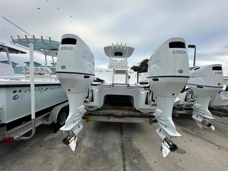 Slide: The Image of 2025 Twin Vee 240 GFX CC boat with dual 150 horsepower engines, docked on a trailer. - 4