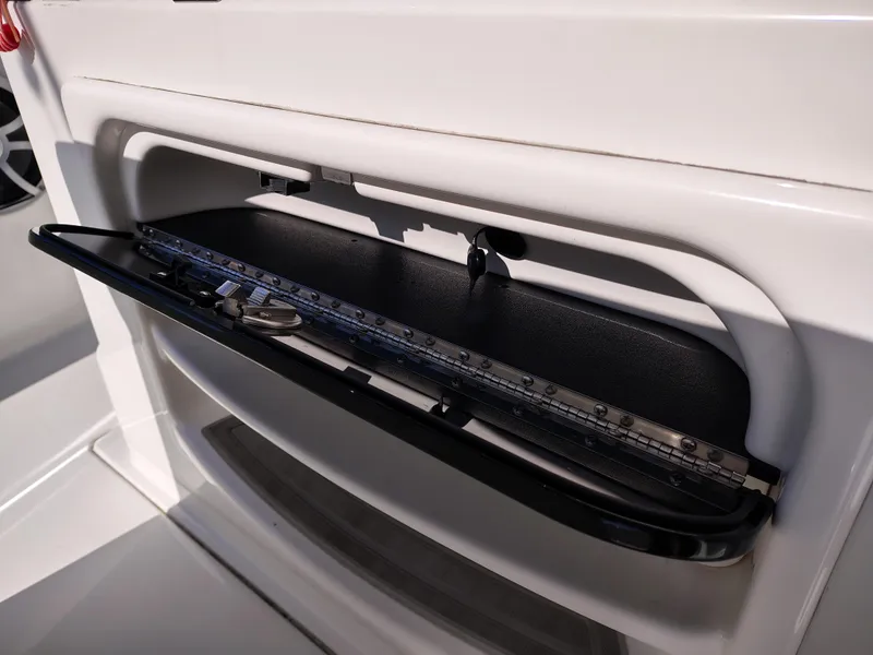 Slide: The Image of 2024 Parker 2900 Center Console boat storage compartment with measuring tools. - 11