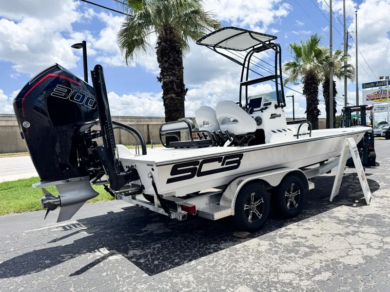 Slide: The Image of 2025 SCB S22 boat on trailer, featuring powerful 300 horsepower engine, parked under palm trees. - 2