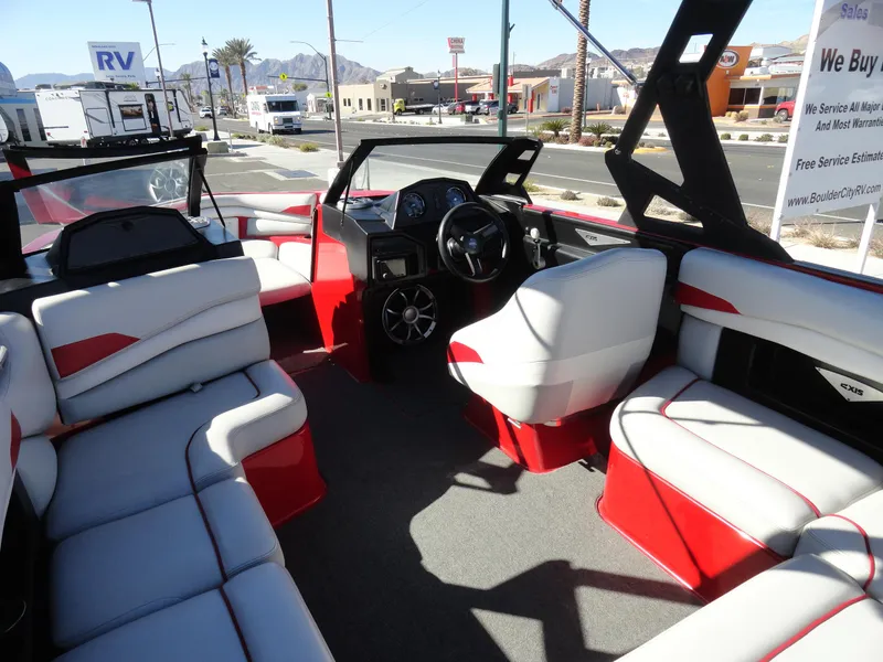 Slide: The Image of 2016 Axis A22 boat interior with red and white seating, dashboard, and steering wheel. - 10
