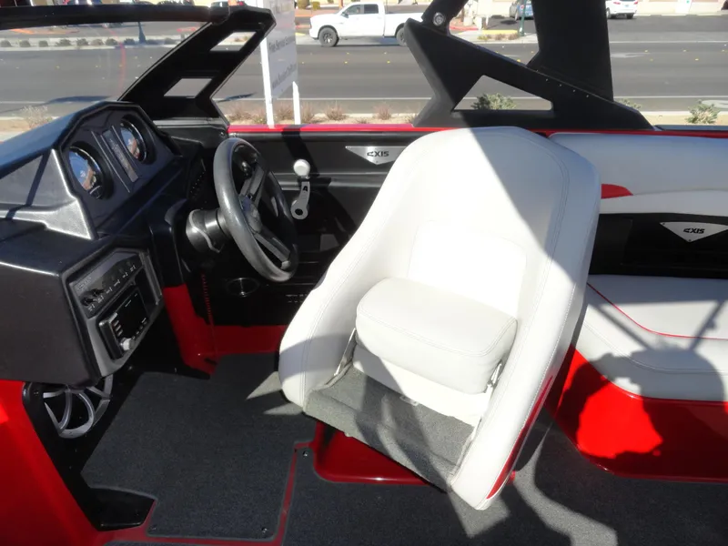 Slide: The Image of 2016 Axis A22 boat interior with steering wheel and white captain's chair. - 16