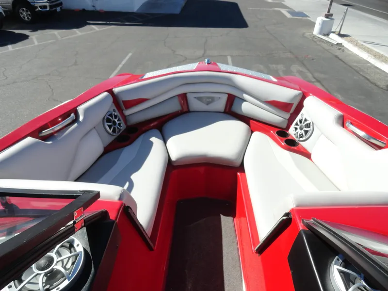 Slide: The Image of 2016 Axis A22 boat interior with red and white seating and built-in speakers. - 21