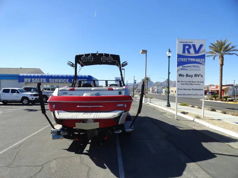Slide: The Image of 2016 Axis A22 boat parked near RV sales lot under clear blue sky. - 26