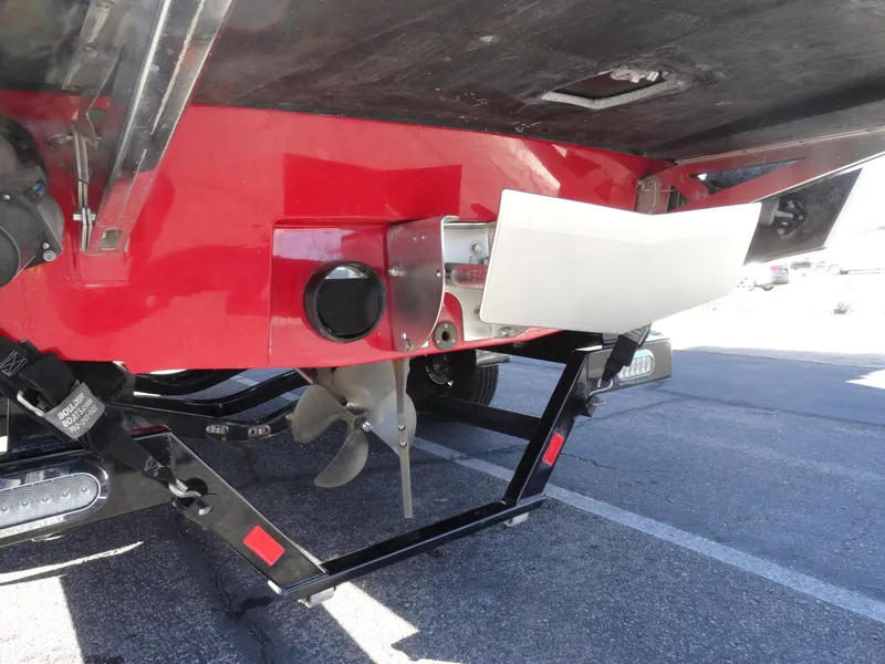 Slide: The Image of 2016 Axis A22 boat underside showing propeller and trailer in a parking lot. - 27