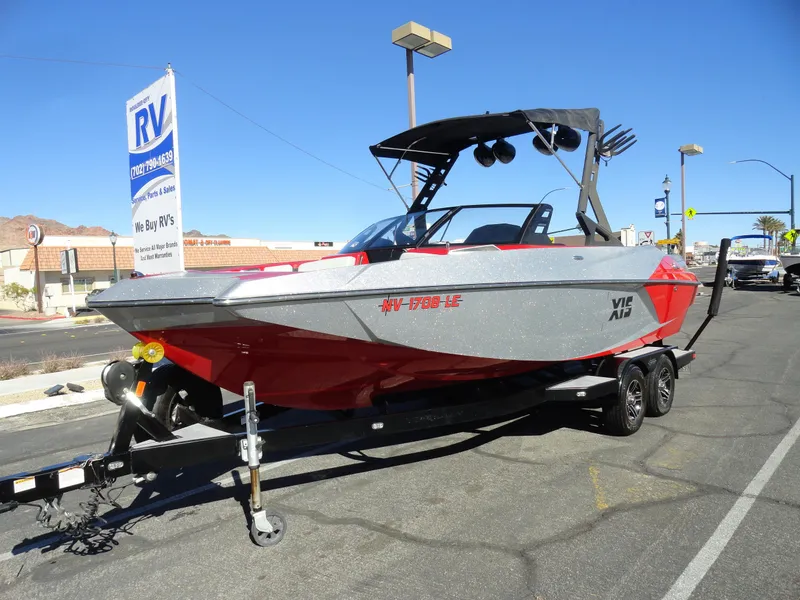 Slide: The Image of 2016 Axis A22 boat on trailer, parked outdoors near RV dealership. - 5