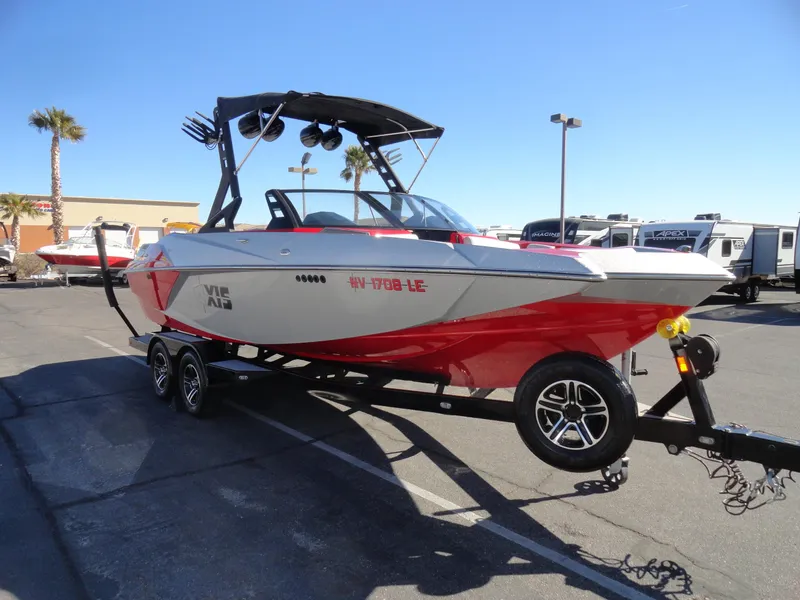 Slide: The Image of 2016 Axis A22 boat on trailer, red and white design, parked outdoors. - 7