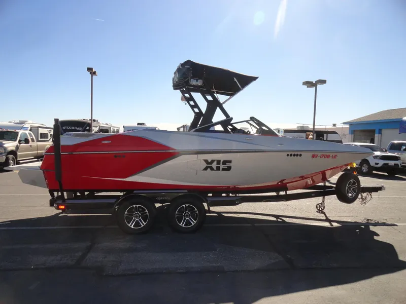 Slide: The Image of 2016 Axis A22 boat on trailer, red and white design, parked outdoors. - 8