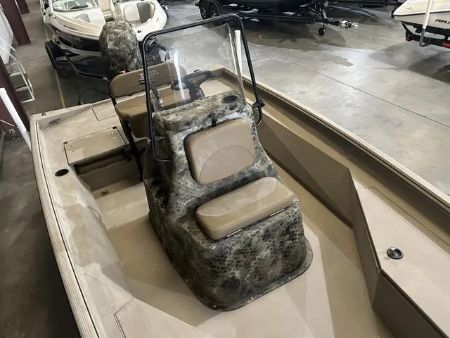 Slide: The Image of 2022 Excel Bay Pro 203 boat interior with camouflage seating and steering console. - 11