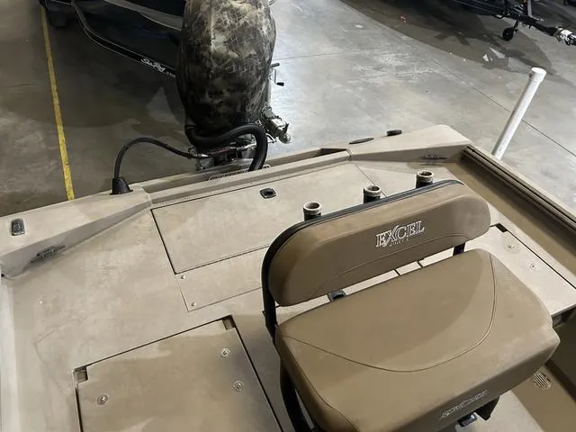 Slide: The Image of 2022 Excel Bay Pro 203 boat interior with seating and motor in a garage. - 13