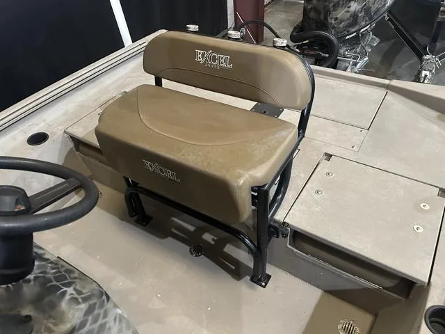 Slide: The Image of 2022 Excel Bay Pro 203 boat seat and steering area, featuring tan upholstery. - 14
