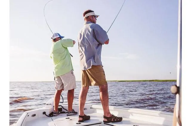 Slide: The Image of Two people fishing on a 2022 Excel Bay Pro 203 boat in open water. - 28