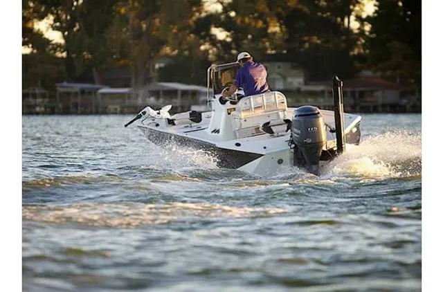 Slide: The Image of 2022 Excel Bay Pro 203 boat cruising on a lake at sunset. - 31