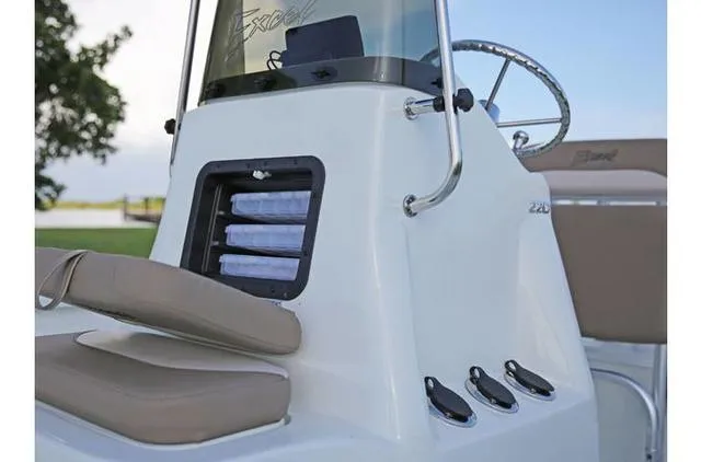 Slide: The Image of 2022 Excel Bay Pro 203 boat console with storage compartments and steering wheel. - 33