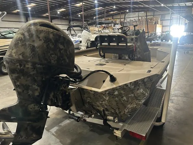 Slide: The Image of 2022 Excel Bay Pro 203 boat in warehouse, camo design, outboard motor, trailer. - 4