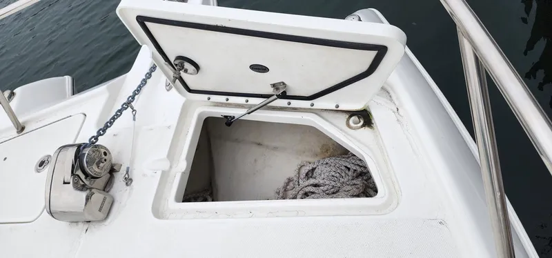 Slide: The Image of 2016 World Cat 2780 Glacier Bay Edition boat anchor storage compartment with open hatch. - 16