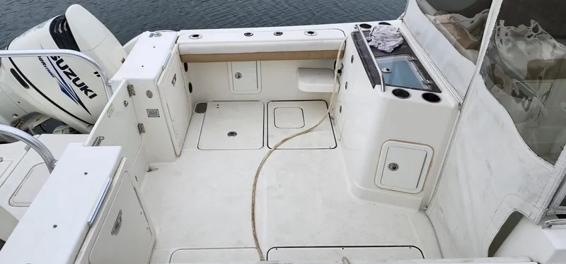 Slide: The Image of 2016 World Cat 2780 Glacier Bay Edition boat deck with Suzuki engine, featuring storage and seating. - 17
