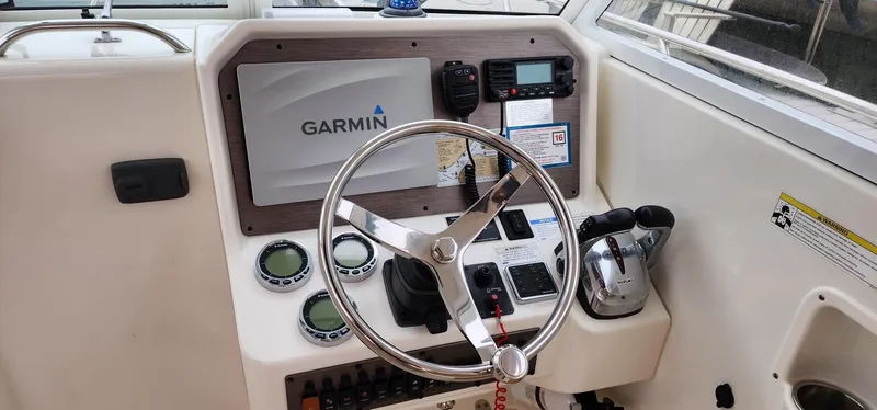 Slide: The Image of 2016 World Cat 2780 Glacier Bay Edition helm with Garmin navigation system and controls. - 19