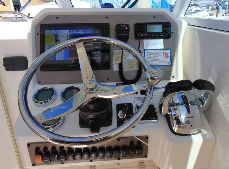 Slide: The Image of 2016 World Cat 2780 Glacier Bay Edition helm with steering wheel and navigation controls. - 21