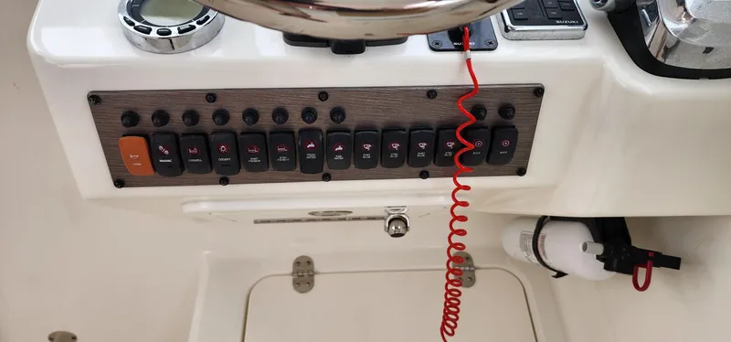 Slide: The Image of Control panel of 2016 World Cat 2780 Glacier Bay Edition boat with switches and gauges. - 27