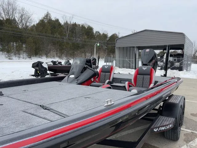 Slide: The Image of 2025 Phoenix 921 ELITE bass boat with red and gray seating, parked outdoors in winter. - 12