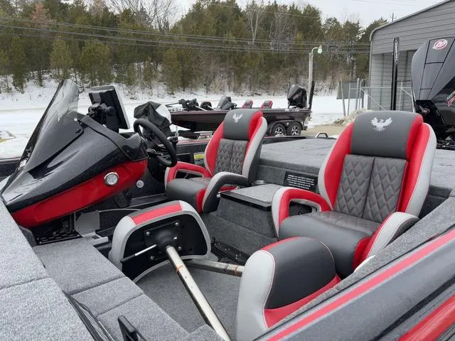 Slide: The Image of 2025 Phoenix 921 ELITE boat interior with red and gray seating, steering console, and dashboard. - 13