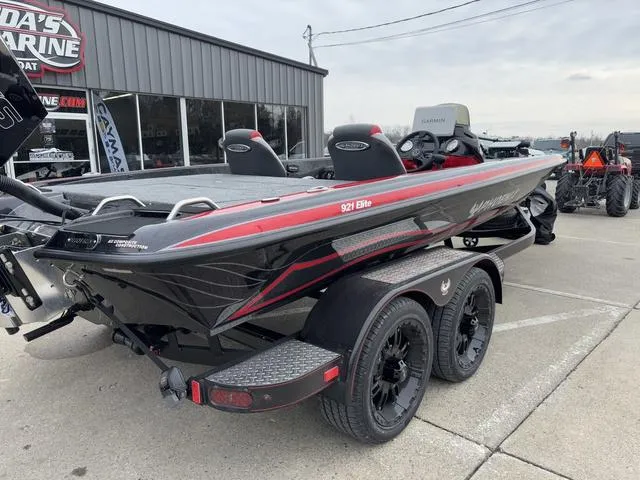 Slide: The Image of 2025 Phoenix 921 ELITE boat on trailer, black and red design, parked outside a marine shop. - 4