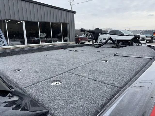 Slide: The Image of 2025 Phoenix 921 ELITE boat deck with fishing equipment, parked outside a showroom. - 8